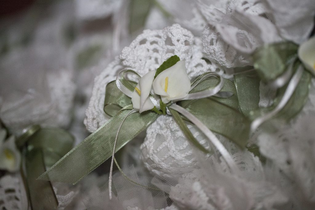 sacchettino realizzato all'uncinetto e decorato con fiorellini e nastri in raso e organza
